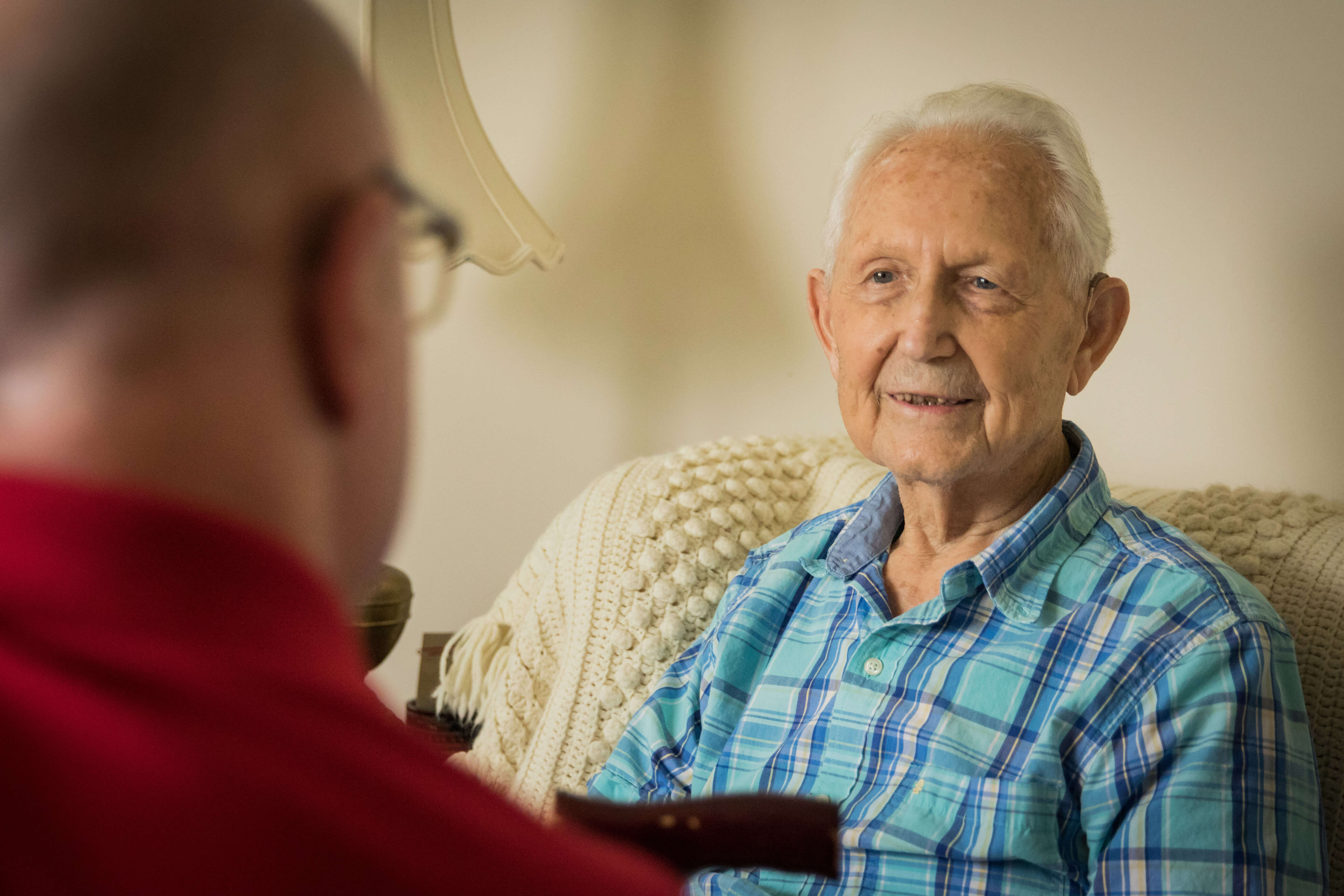 Home health social worker speaks to client, and client smiles.