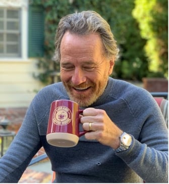 Bryan Cranston drinks coffee out of a LeGrand Coffee House coffee cup